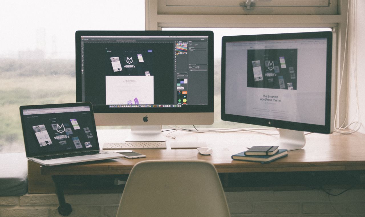 heros-img Espace de travail élégant et efficace avec plusieurs écrans, un ordinateur portable et un smartphone, mettant en avant un projet de conception web.